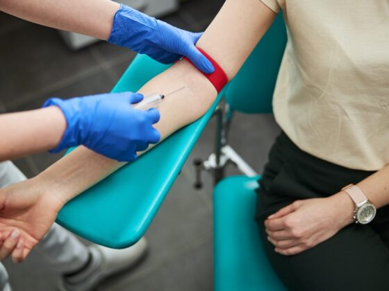 Professional female phlebotomist performing a venipuncture procedure